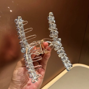 Detail of transparent crystal beads on a resin shark hair clip with strong metal spring