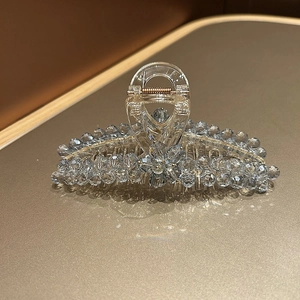 Close-up of light blue crystal shark hair clip with floral rhinestone details