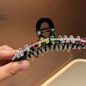 Detail shot of black acrylic hair claw clip with vibrant multicolor crystals
