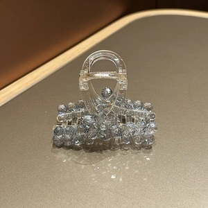 Macro detail of a light blue crystal hair claw clip with floral bead patterns