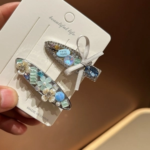 Detail of silver alloy hair clips with blue rhinestones and handmade ribbon bows