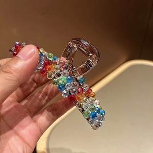 Detailed macro view of high-end colorful faceted crystal beads on champagne hair claw
