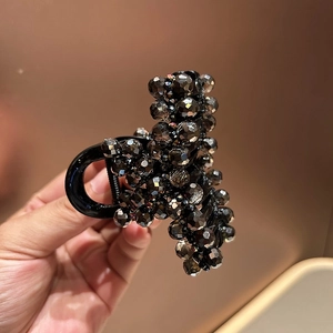 Detail showing high-quality black resin hair claw with shimmering dark grey beads