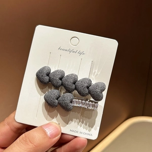Set of two denim blue heart hair clips with sparkling rhinestones on display card