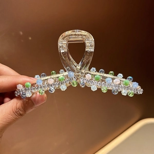 Detail of luxury hair claw clip with colorful crystal beads and shiny rhinestones