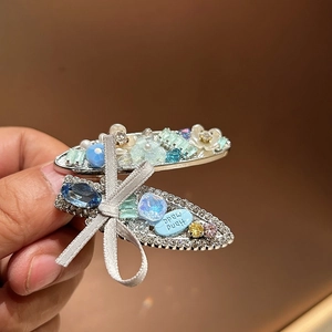 Elegant silver bow hair clips with blue rhinestones and beads for a sweet summer look