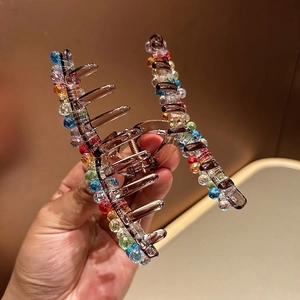 Detail of crystal hair claw clip with colorful rhinestones on brown acrylic base