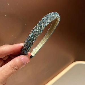 Close-up of hand-woven headband with sparkling grey crystals on a dark base