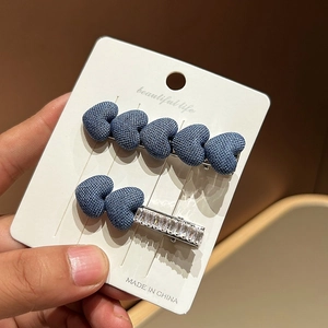 Denim heart hair clip set with sparkling rhinestones on elegant white card holder