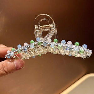 Macro shot of luxury hair claw clip with colorful crystal beads and gold spring mechanism