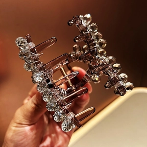 Detailed macro view of the crystal-embellished resin hair claw clip in a warm brown tone
