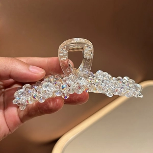 Détail des perles en cristal sur la pince à cheveux transparente couleur aurore