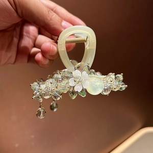 Detailed macro view of beaded hair claw clip with crystal drops and floral ornaments