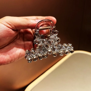 Detail of luxury hair claw with grey crystal beads on dark brown acrylic base