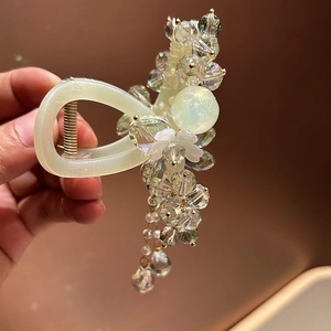 Detail of beaded cream hair claw clip with crystals, petals and pearl tassels
