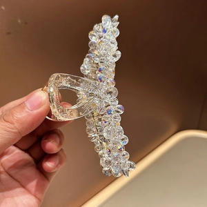 Détail d'une grande pince à cheveux en cristal avec des perles facettées scintillantes