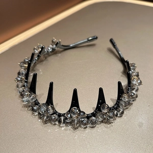 Détail des perles en cristal et des dents dentelées sur un serre-tête noir de luxe