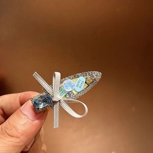 Macro view of handmade bow hair clip with colorful crystals and deep blue teardrop gems