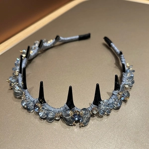 Detail of grey-blue crystal headband featuring black spikes and non-slip inner teeth