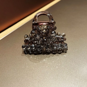 Macro detail of brown crystal hair claw clip with faceted dark grey rhinestones