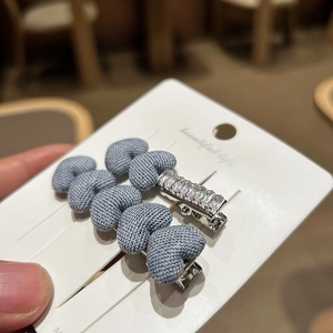 Detailed shot of denim blue heart fabric hair clips and sparkling rhinestone hairpins