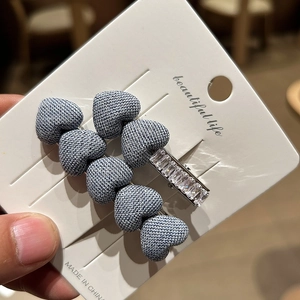 Detail of denim blue heart hair clip and rectangular rhinestone barrette on card