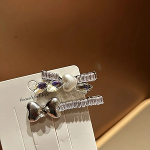 Dettaglio di fermagli per capelli con fiocco di strass, perla e cuore di cristallo
