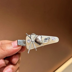 Pince à cheveux crème avec nœud argenté, cœur et strass pour un look élégant