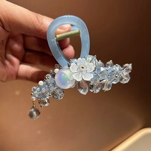 Close-up of handmade blue crystal beaded hair claw with 3D floral and pearl accents