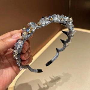 Detail of crystal headband with blue gems, satin wrap, and anti-slip wavy teeth