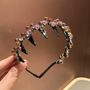 Detail of purple and amber faceted crystals on a black non-slip headband with teeth