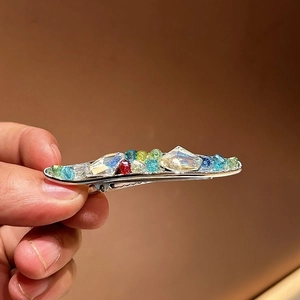 Détail d'une pince à cheveux faite main avec des cristaux colorés sur base en alliage
