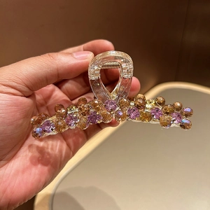 Vue détaillée d'une grande pince à cheveux avec perles mauves et cristaux brillants