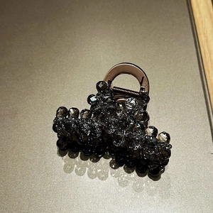Detailed view of translucent brown hair claw clip with grey and black crystal beadwork