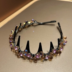 Detail of crystal headband with pink and amber beads on a metallic gold base