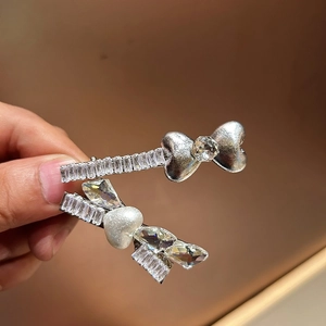 Dettaglio delle clip per capelli in argento con cristalli a cuore e perle bianche