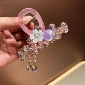 Detail of pink crystal beaded hair claw clip with floral accents and aurora purple beads