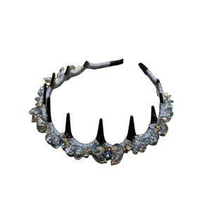 Gothic style crystal headband with black spikes and blue rhinestones on white base