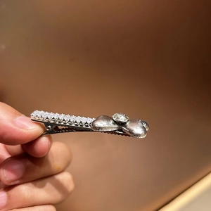 Dettaglio del fermaglio per capelli argento con strass scintillanti e petali a cuore