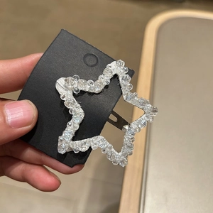 Close-up of star-shaped hair clip with shimmering crystal beads on black display card