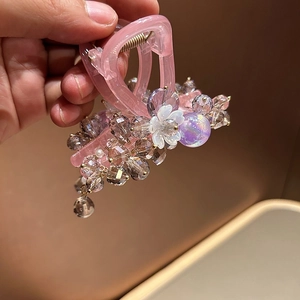 Close-up of pink crystal beads and flower details on the handcrafted resin hair claw clip