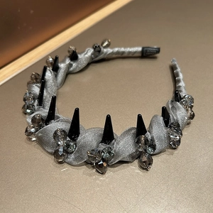 Detail of silver mesh headband with alternating black studs and grey crystals on satin fabric
