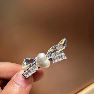 Dettaglio di un fermaglio argento con perla a cuore e zirconi marquise brillanti