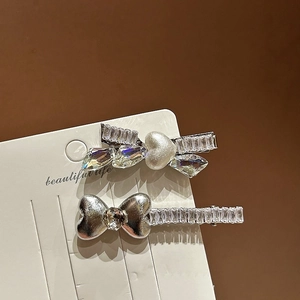 Dettaglio del set di due fermagli per capelli in argento con strass e fiocco di perle