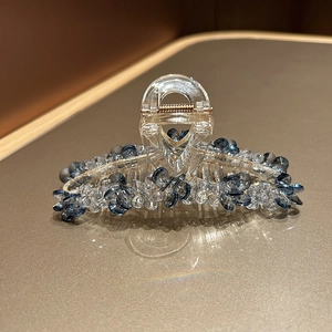 Vue détaillée de la pince à cheveux de luxe avec cristaux bleus sur surface chaude