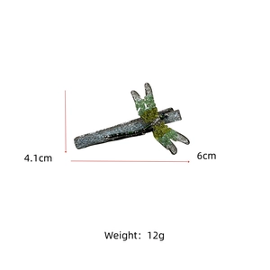 Detail view of dragonfly hair clip with green crystals and dimensions 6cm by 4.1cm