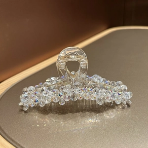 Détail de la pince à cheveux en cristal avec strass étincelants sur cuir foncé