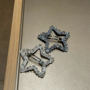 Star-shaped crystal beaded hair clips in light blue and silver on a display stand