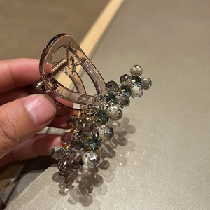 Macro detail of handmade hair claw clip with grey crystal beads and translucent brown resin