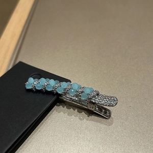 Elegant hair clip with blue beads and sparkling rhinestones on silver metal base